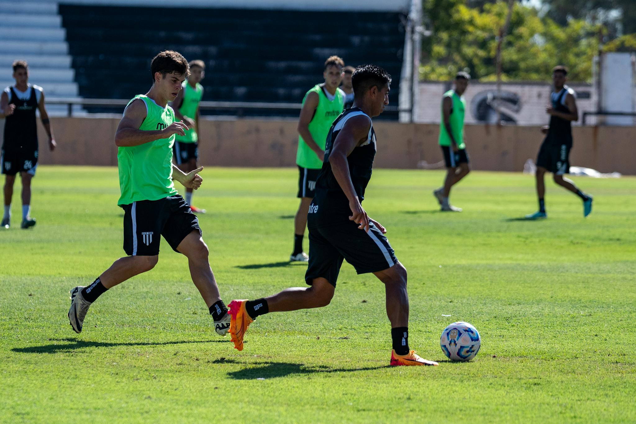 Soccer players in action during a training session on a bright sunny day.