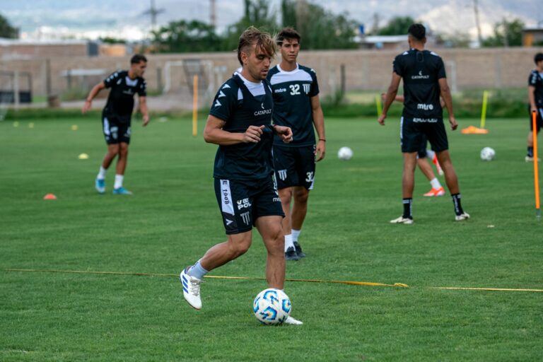Soccer players train intensely on a lush field, honing their skills and teamwork.
